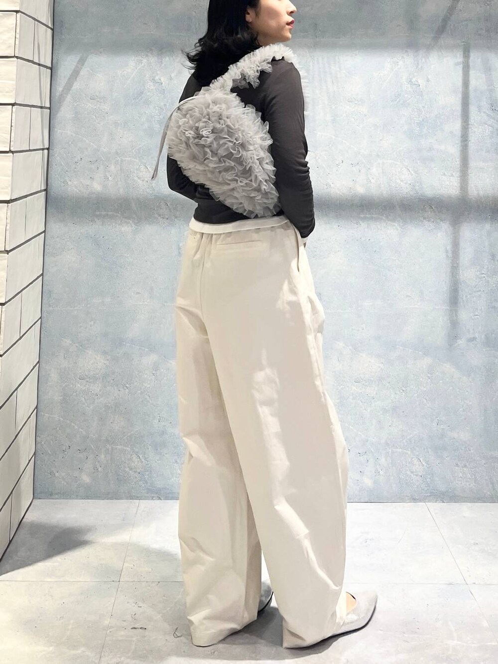 グレー系のショルダーバッグ、グレー系のTシャツ/カットソー、シルバー系のパンプスを着用したレディースの春コーディネートの2枚目の写真