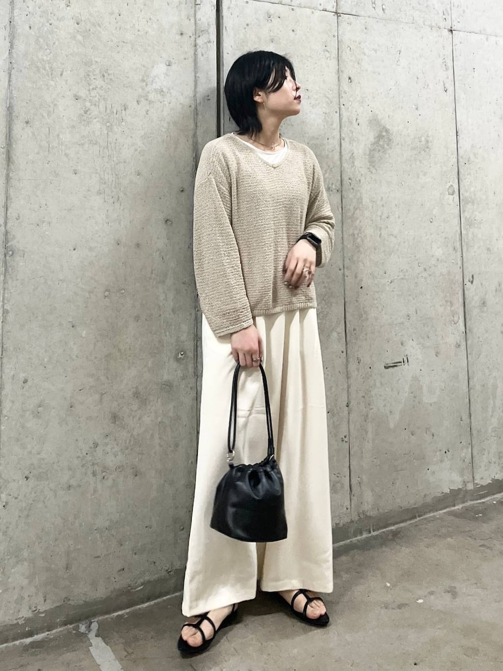 ブラック系のショルダーバッグ、ブラック系のサンダル、ホワイト系のTシャツ/カットソーを着用したレディースの春コーディネートの8枚目の写真