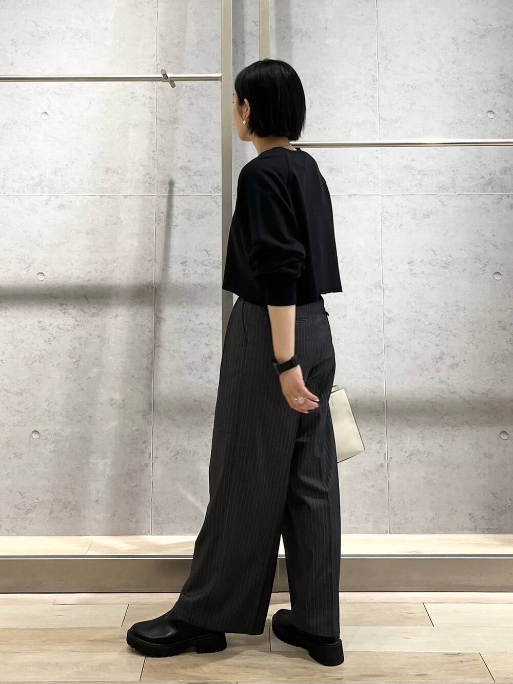 ブラック系のTシャツ/カットソー、ホワイト系のショルダーバッグ、グレー系のその他パンツを着用したレディースの秋コーディネートの6枚目の写真