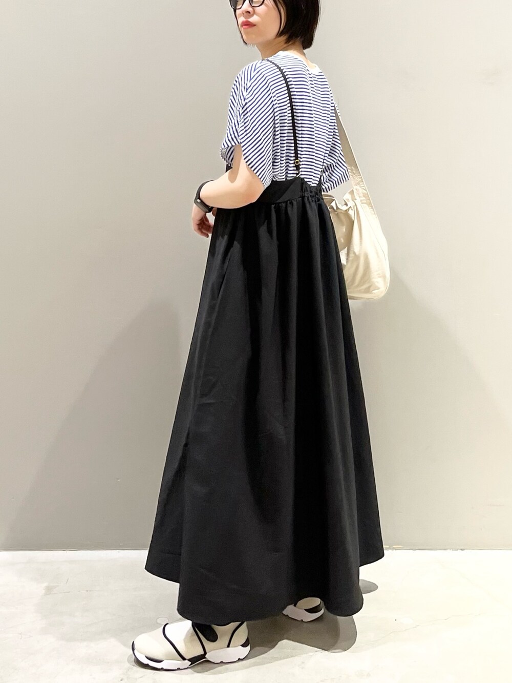 ブラック系のワンピース、ブルー系のTシャツ/カットソー、ホワイト系のショルダーバッグを着用したレディースの秋コーディネートの2枚目の写真