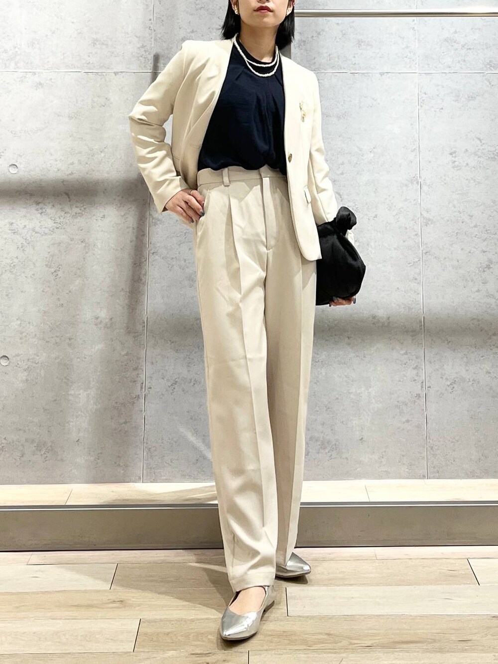 ブラック系のハンドバッグ、ブルー系のシャツ/ブラウス、ホワイト系のノーカラージャケットを着用したレディースの冬コーディネートの9枚目の写真