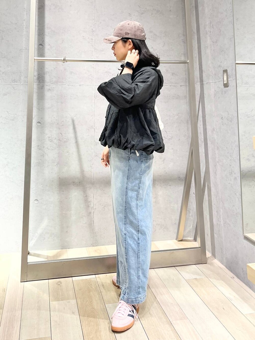 ホワイト系のショルダーバッグ、ブルー系のデニムスカート、ブラウン系のキャップを着用したレディースの冬コーディネートの5枚目の写真