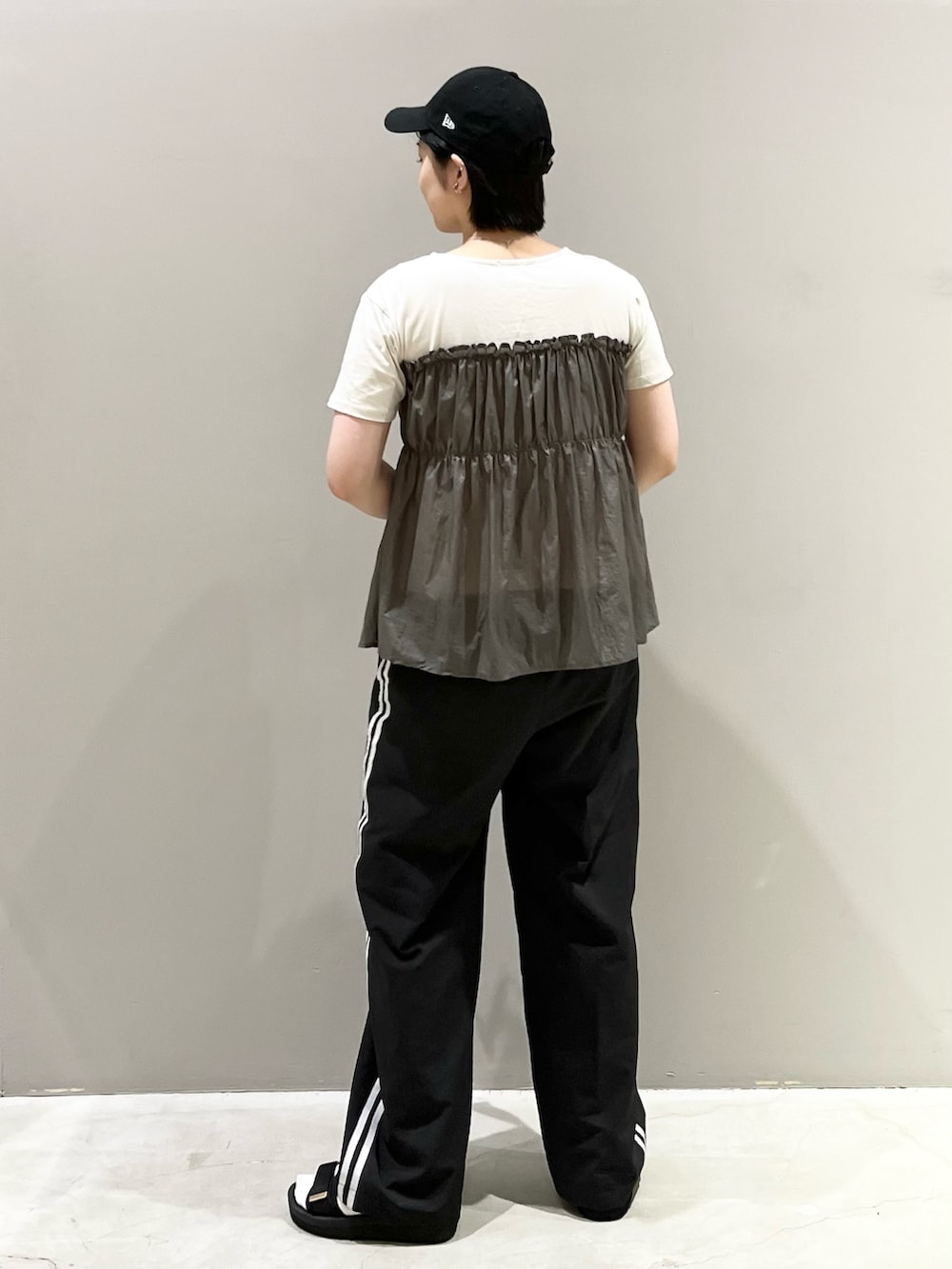 ブラック系のパンツ、ブラック系のサンダル、ゴールド系のハンドバッグを着用したレディースの秋コーディネートの4枚目の写真