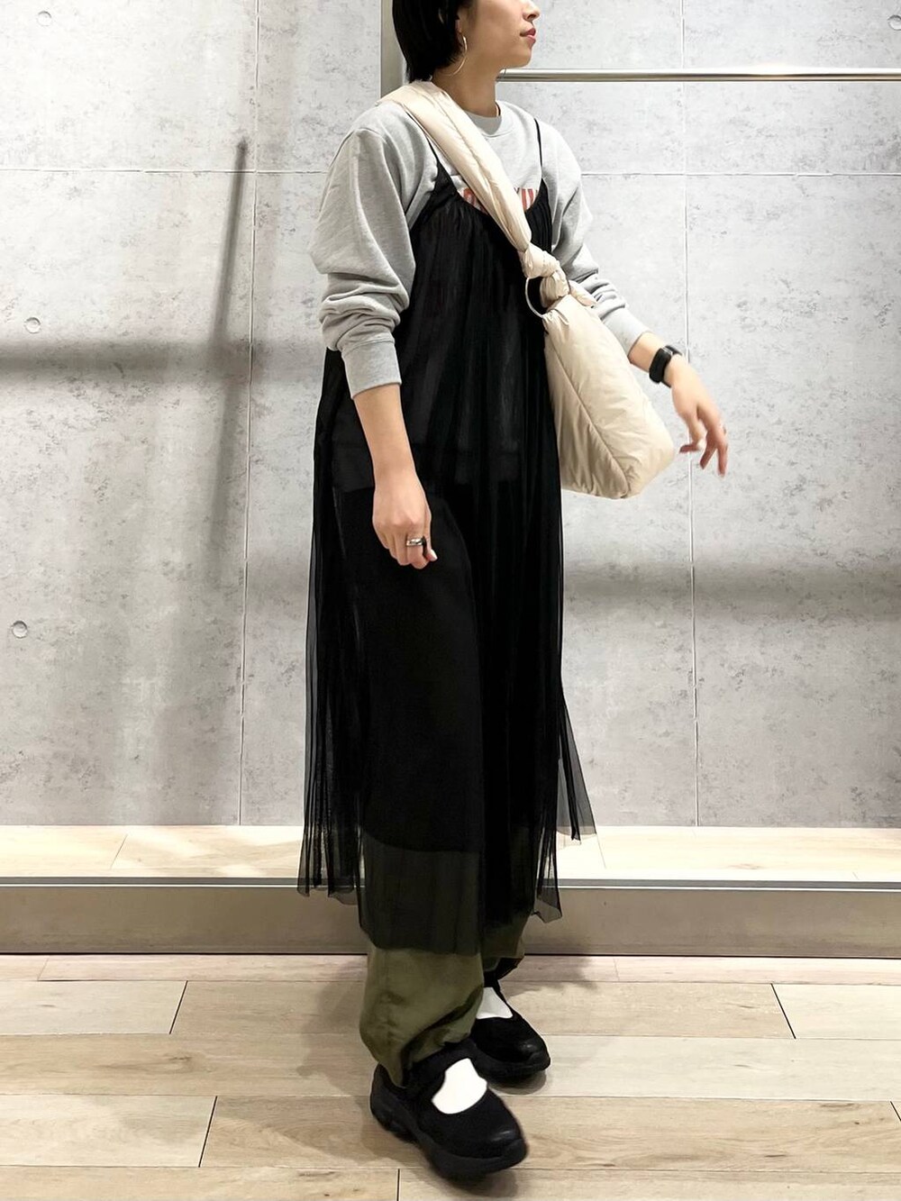 グレー系のスウェット、ブラック系のスニーカー、グリーン系のカーゴパンツを着用したレディースの秋コーディネートの5枚目の写真