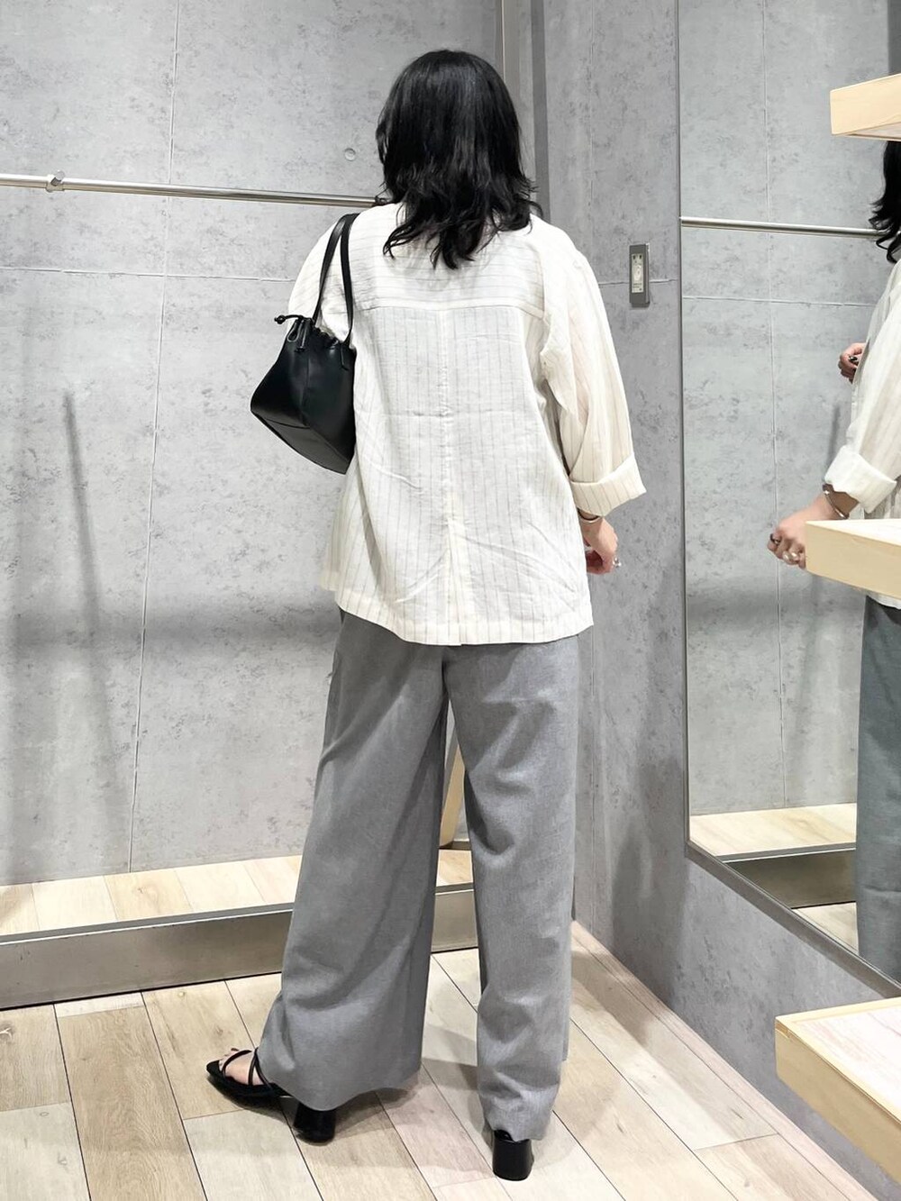 グレー系のその他パンツ、ブラック系のショルダーバッグ、ホワイト系のシャツ/ブラウスを着用したレディースの春コーディネートの2枚目の写真