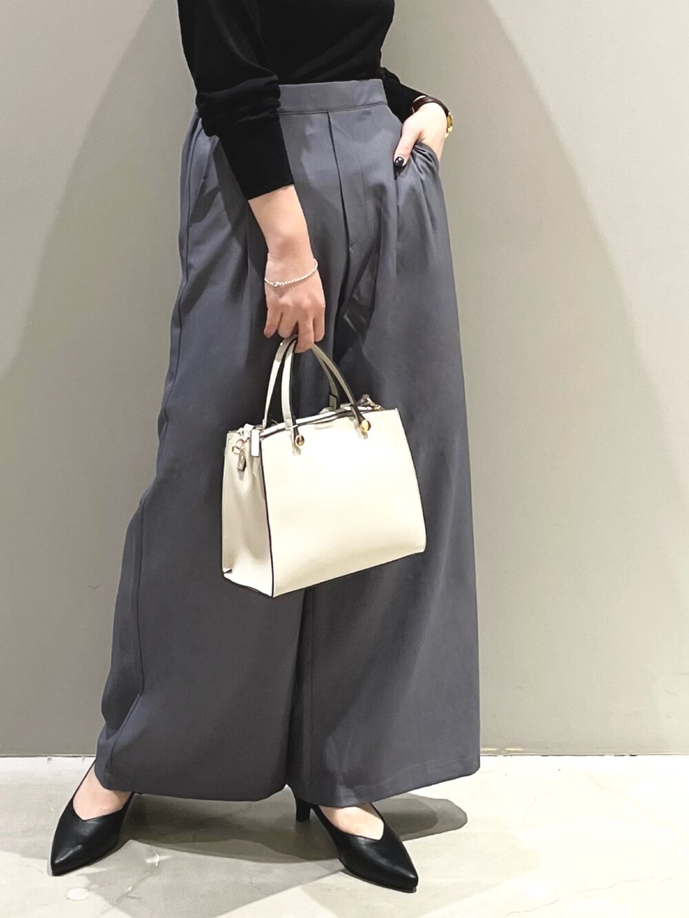 ブラック系のパンプス、ホワイト系のショルダーバッグ、ブラック系のTシャツ/カットソーを着用したレディースの秋コーディネートの4枚目の写真