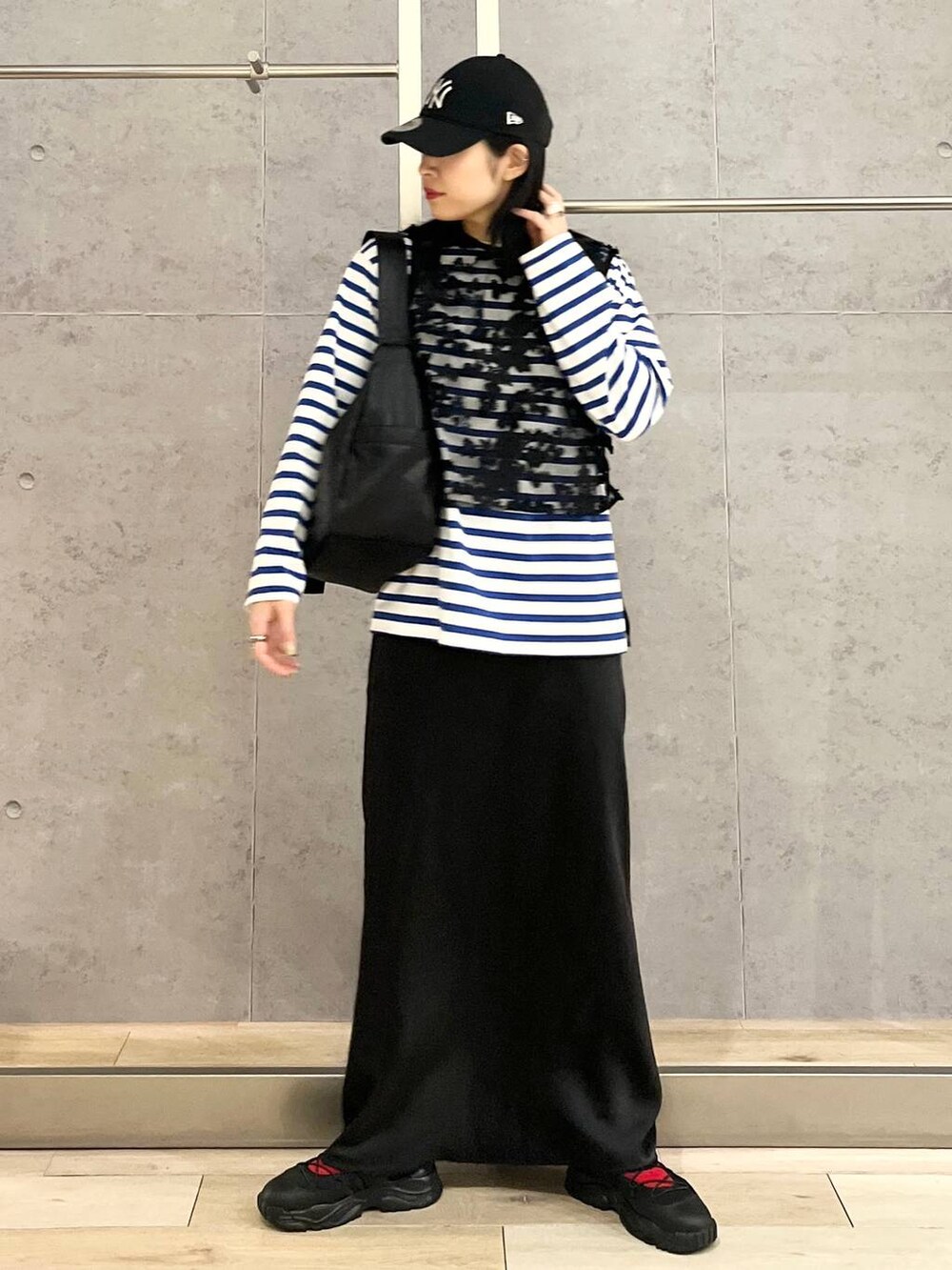 ブラック系のスカート、ブルー系のTシャツ/カットソー、ブラック系のスニーカーを着用したレディースの冬コーディネートの6枚目の写真