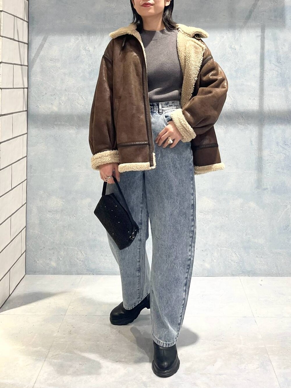 ブラウン系のその他アウター、ブラック系のブーツ、グレー系のニット/セーターを着用したレディースの秋コーディネートの7枚目の写真