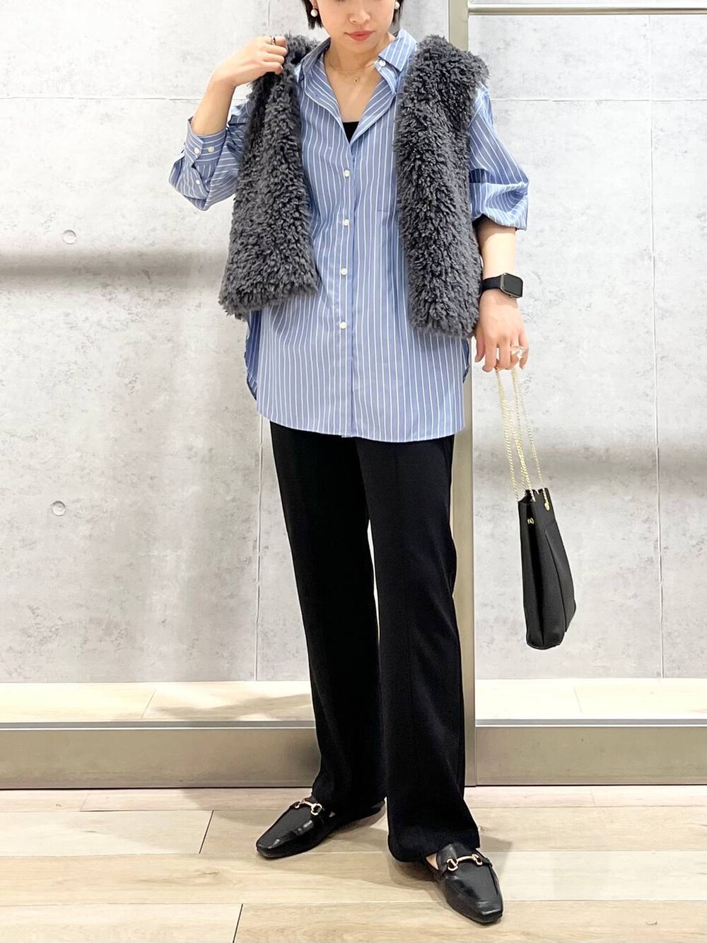 グレー系のベスト、ブラック系のその他パンツ、ブラック系のローファーを着用したレディースの秋コーディネートの6枚目の写真