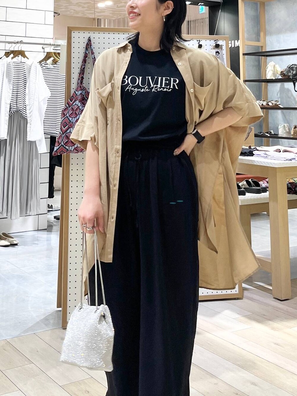 シルバー系のショルダーバッグ、ブラック系のその他パンツ、ホワイト系のサンダルを着用したレディースの夏コーディネートの4枚目の写真