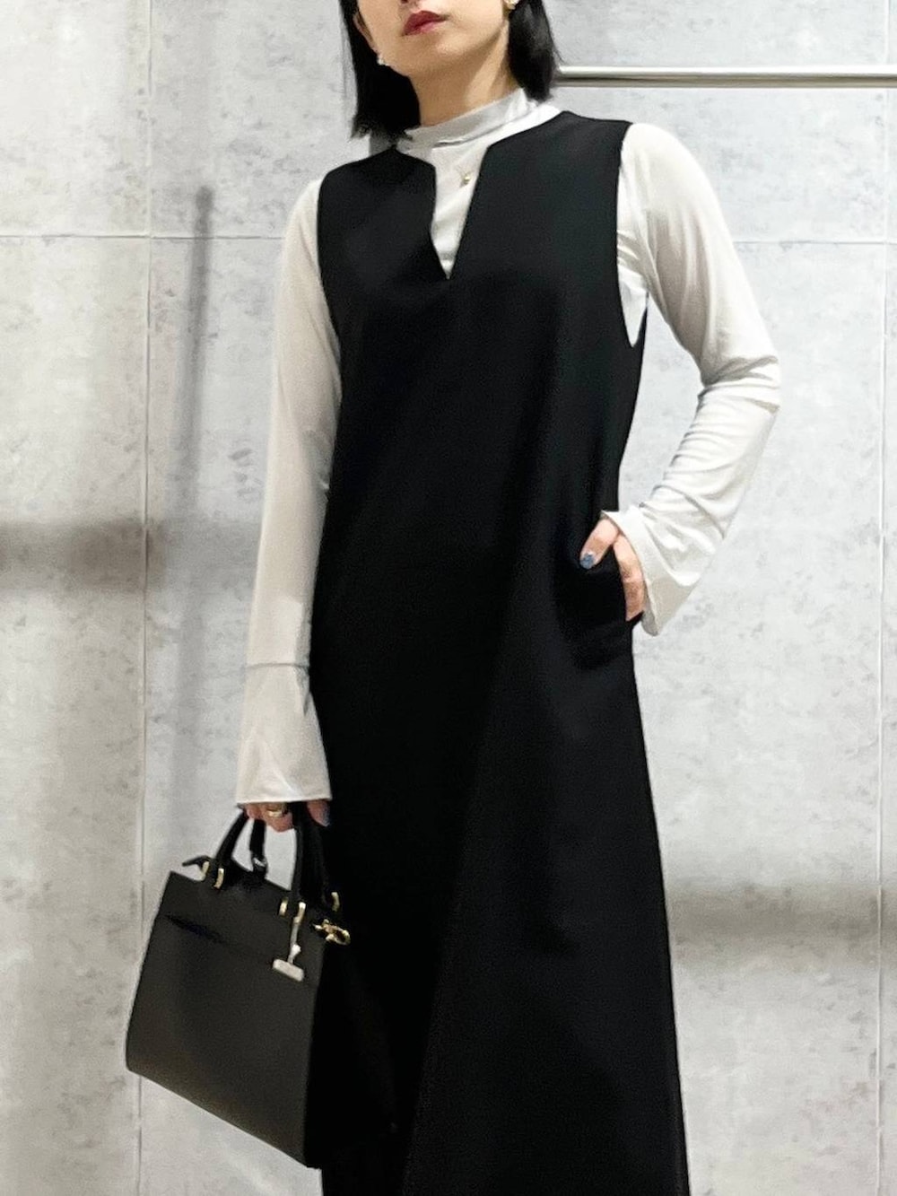 ブラック系のパンプス、グレー系のTシャツ/カットソー、ブラック系のショルダーバッグを着用したレディースの冬コーディネートの6枚目の写真