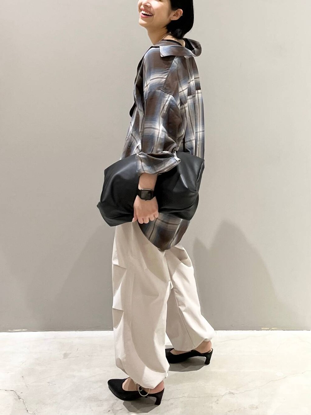 ブラウン系のシャツ/ブラウス、ホワイト系のその他パンツ、ブラック系のハンドバッグを着用したレディースの夏コーディネートの2枚目の写真