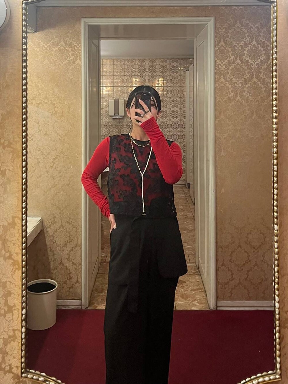 レッド系のTシャツ/カットソー、ブラック系のショルダーバッグ、ブラック系のその他パンツを着用したレディースの冬コーディネートの6枚目の写真