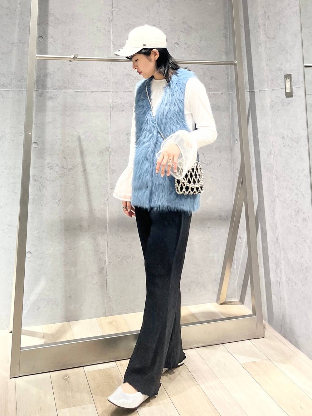 シルバー系のパンプス、ホワイト系のTシャツ/カットソー、ブルー系のベストを着用したレディースの秋コーディネートの2枚目の写真