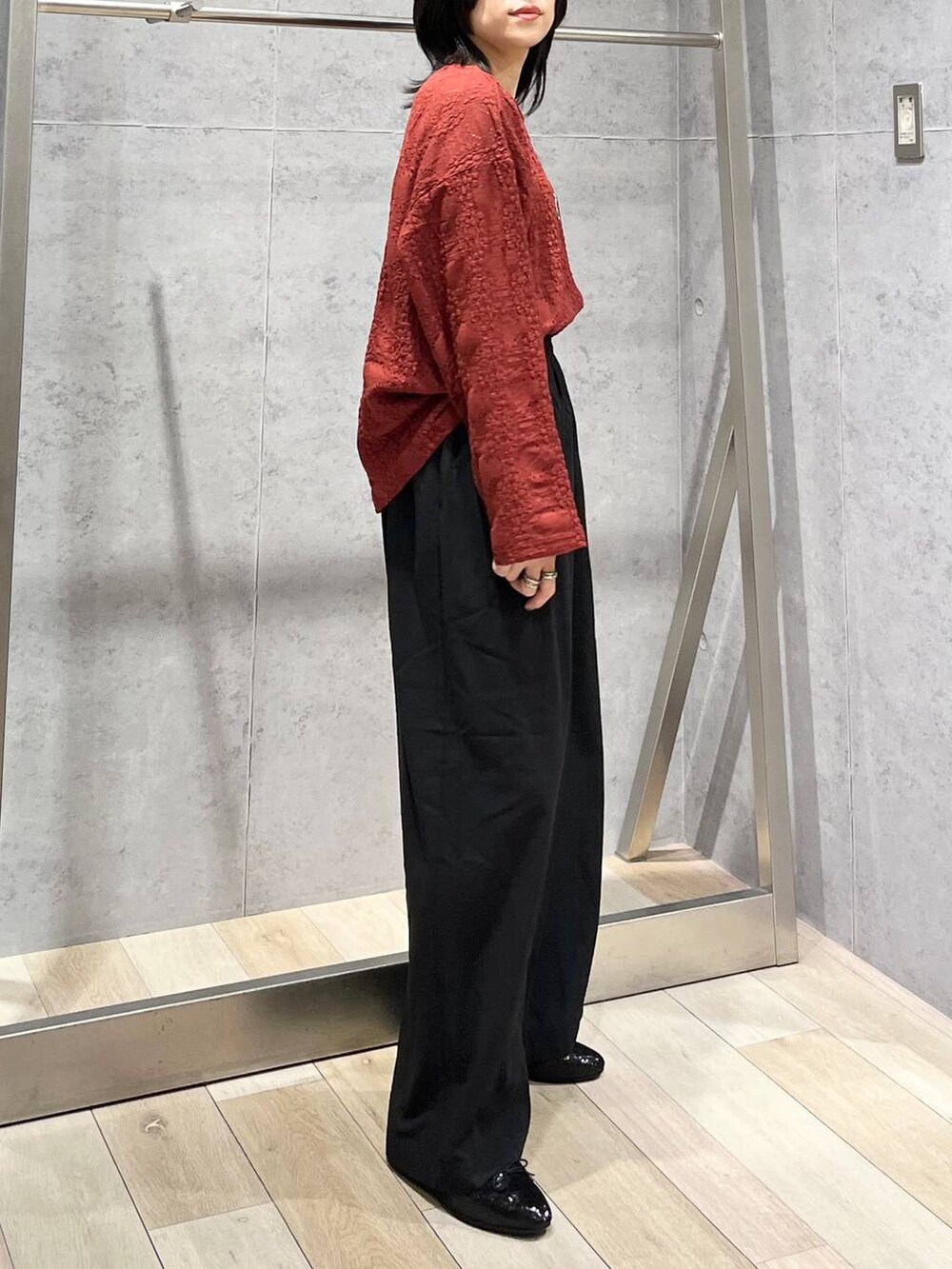 レッド系のTシャツ/カットソー、ブラック系のスラックス、シルバー系のショルダーバッグを着用したレディースの夏コーディネートの6枚目の写真