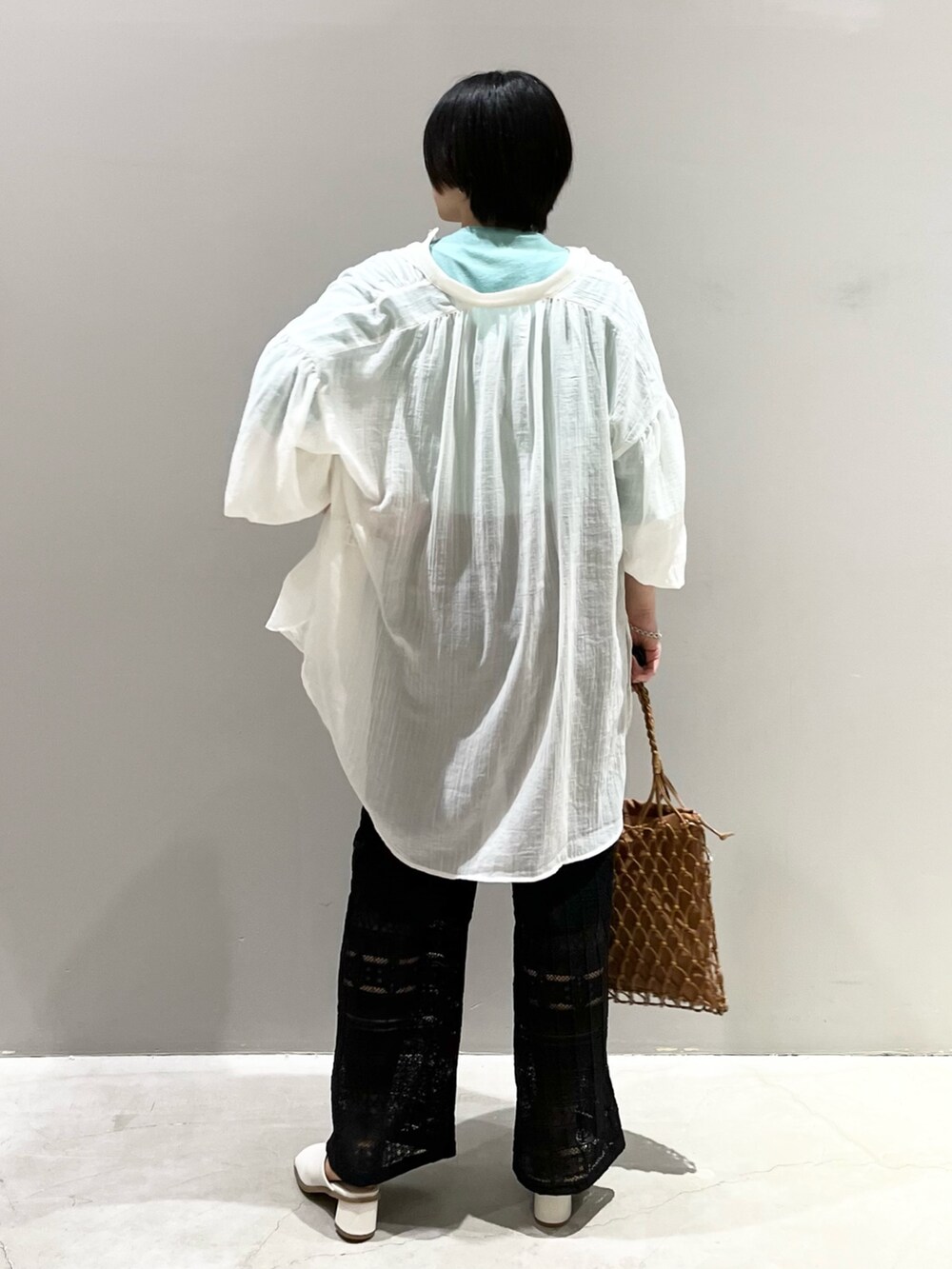 ブラック系のその他パンツ、ホワイト系のサンダル、ベージュ系のバッグを着用したレディースの春コーディネートの7枚目の写真