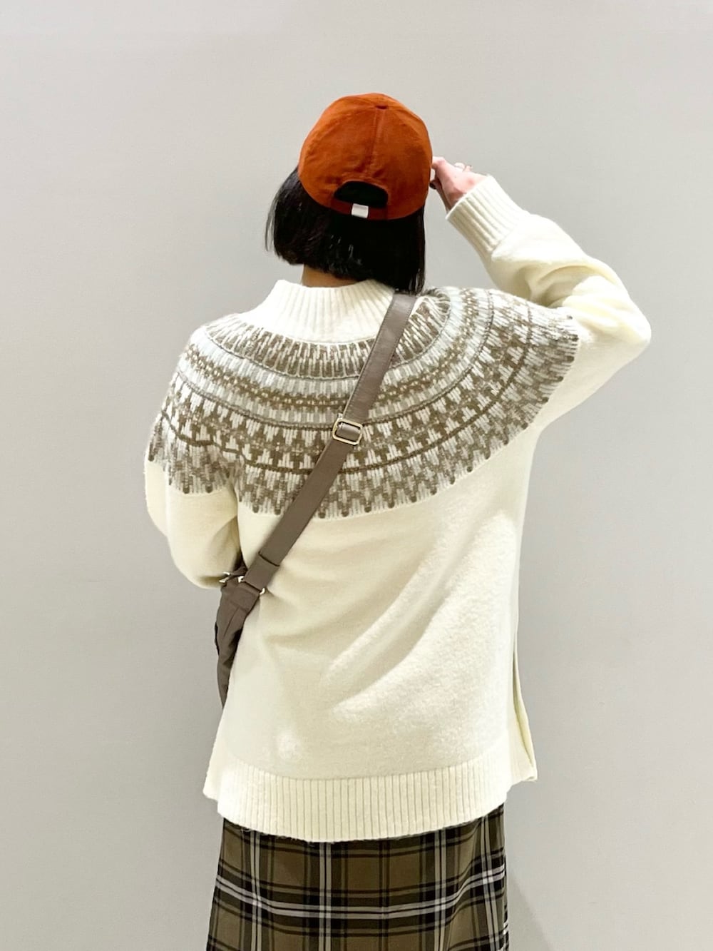 ブラウン系のスカート、ブラウン系のブーツ、ベージュ系のショルダーバッグを着用したレディースの冬コーディネートの5枚目の写真