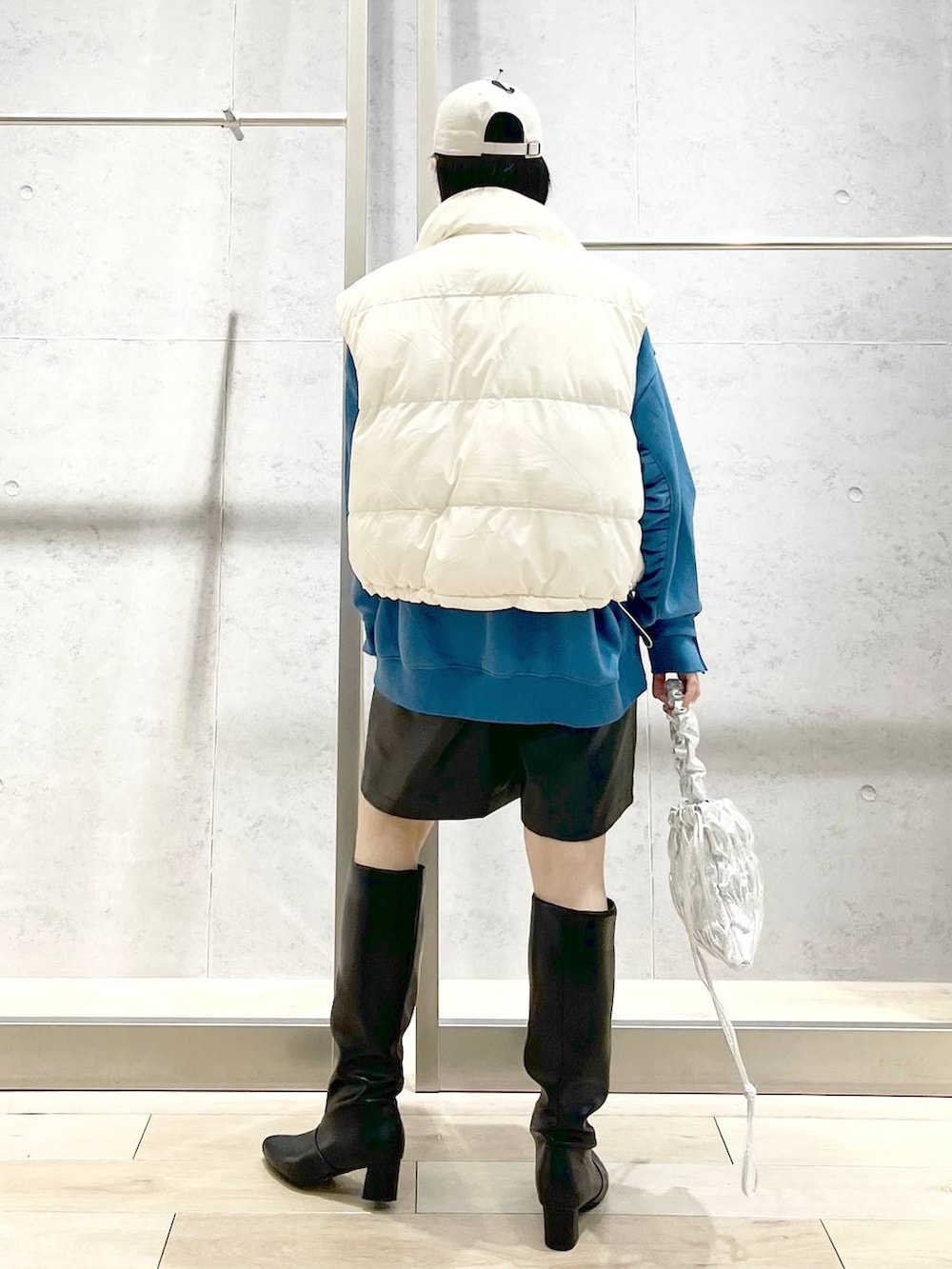 ホワイト系のダウンベスト、シルバー系のショルダーバッグ、ブラック系のその他パンツを着用したレディースの冬コーディネートの4枚目の写真