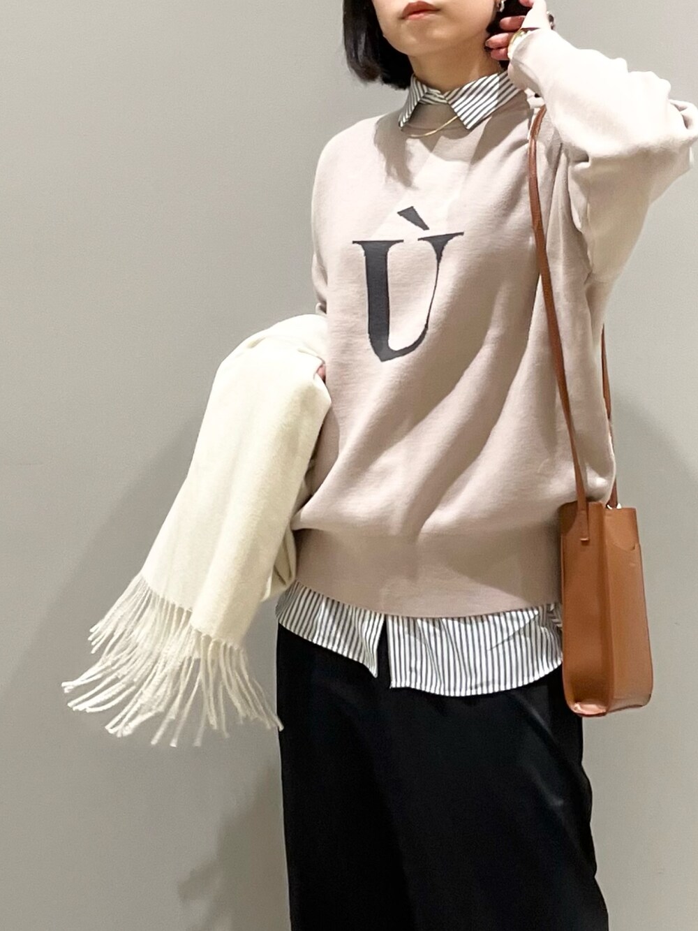 ブラック系のスカート、ブラック系のブーツ、ブラウン系のショルダーバッグを着用したレディースの冬コーディネートの4枚目の写真