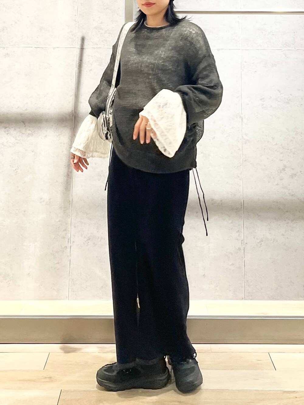 シルバー系のショルダーバッグ、ブラック系のスカート、ホワイト系のTシャツ/カットソーを着用したレディースの秋コーディネートの7枚目の写真