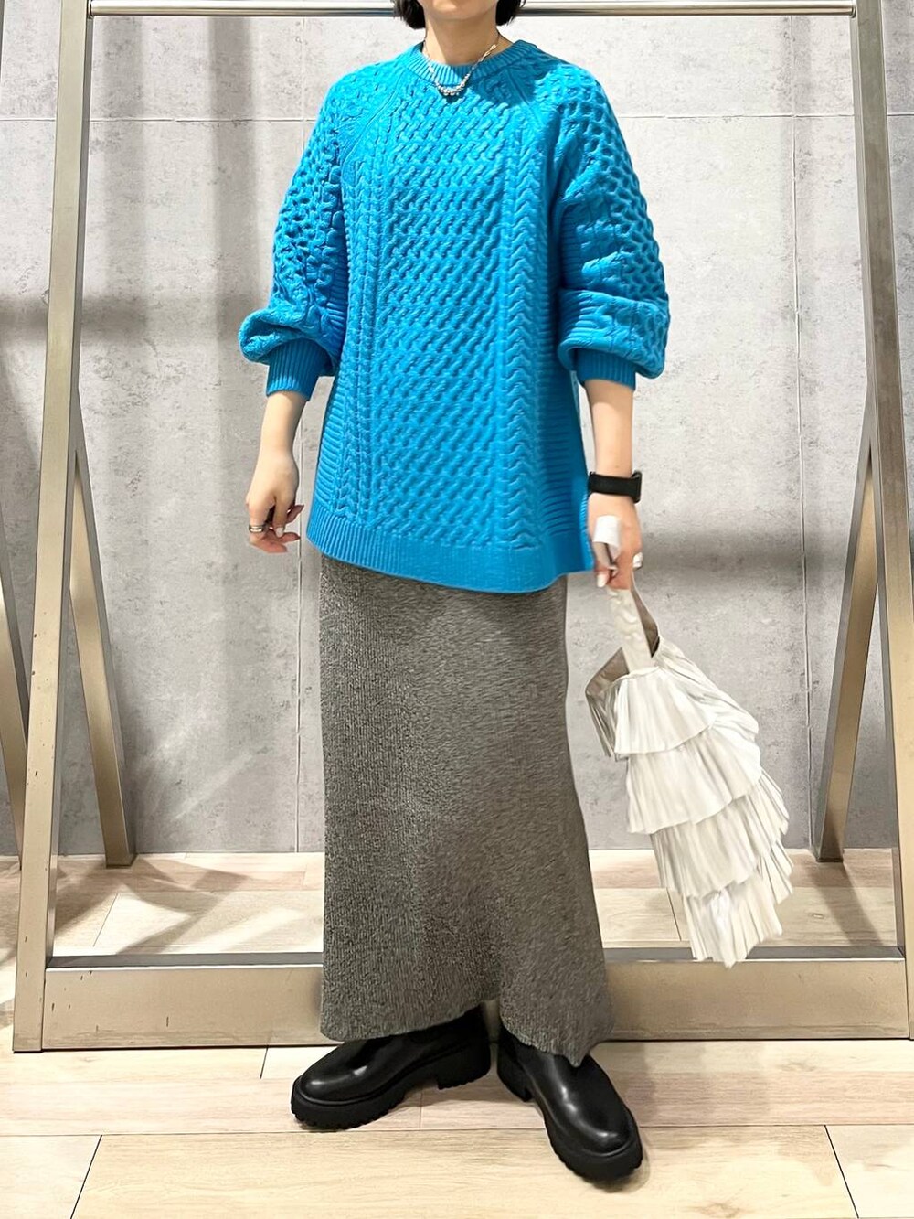 ブラック系のブーツ、シルバー系のトートバッグ、ブルー系のその他トップスを着用したレディースの秋コーディネートの5枚目の写真