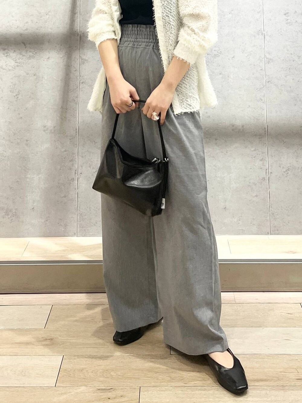 ブラック系のハンドバッグ、ホワイト系のシャツ/ブラウス、ブラック系のパンプスを着用したレディースの春コーディネートの6枚目の写真