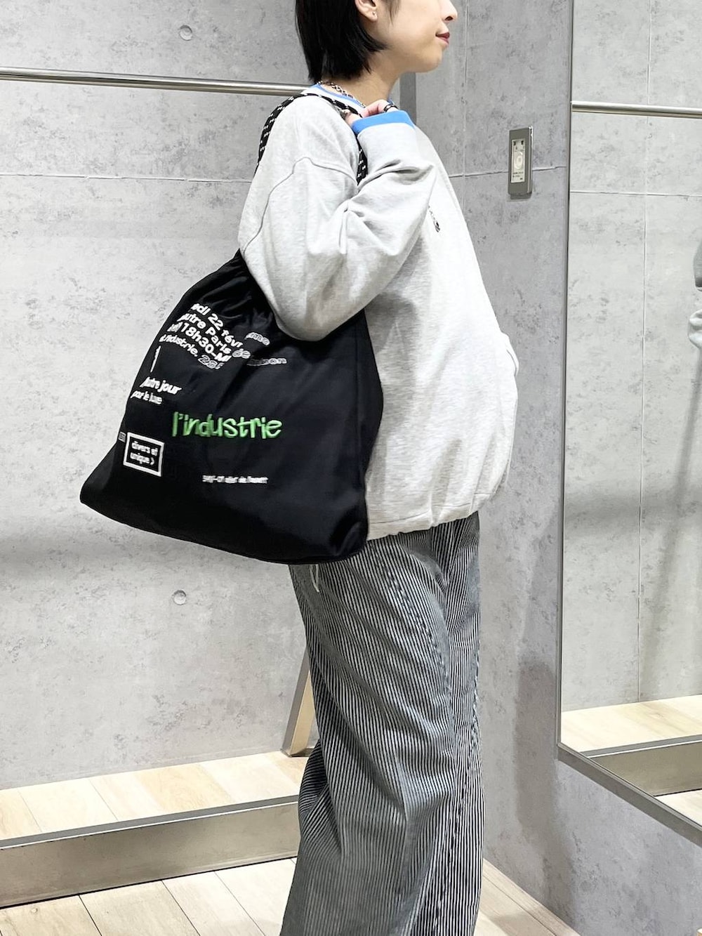 ブラック系のパンプス、ブラック系のトートバッグ、グレー系のTシャツ/カットソーを着用したレディースの冬コーディネートの3枚目の写真