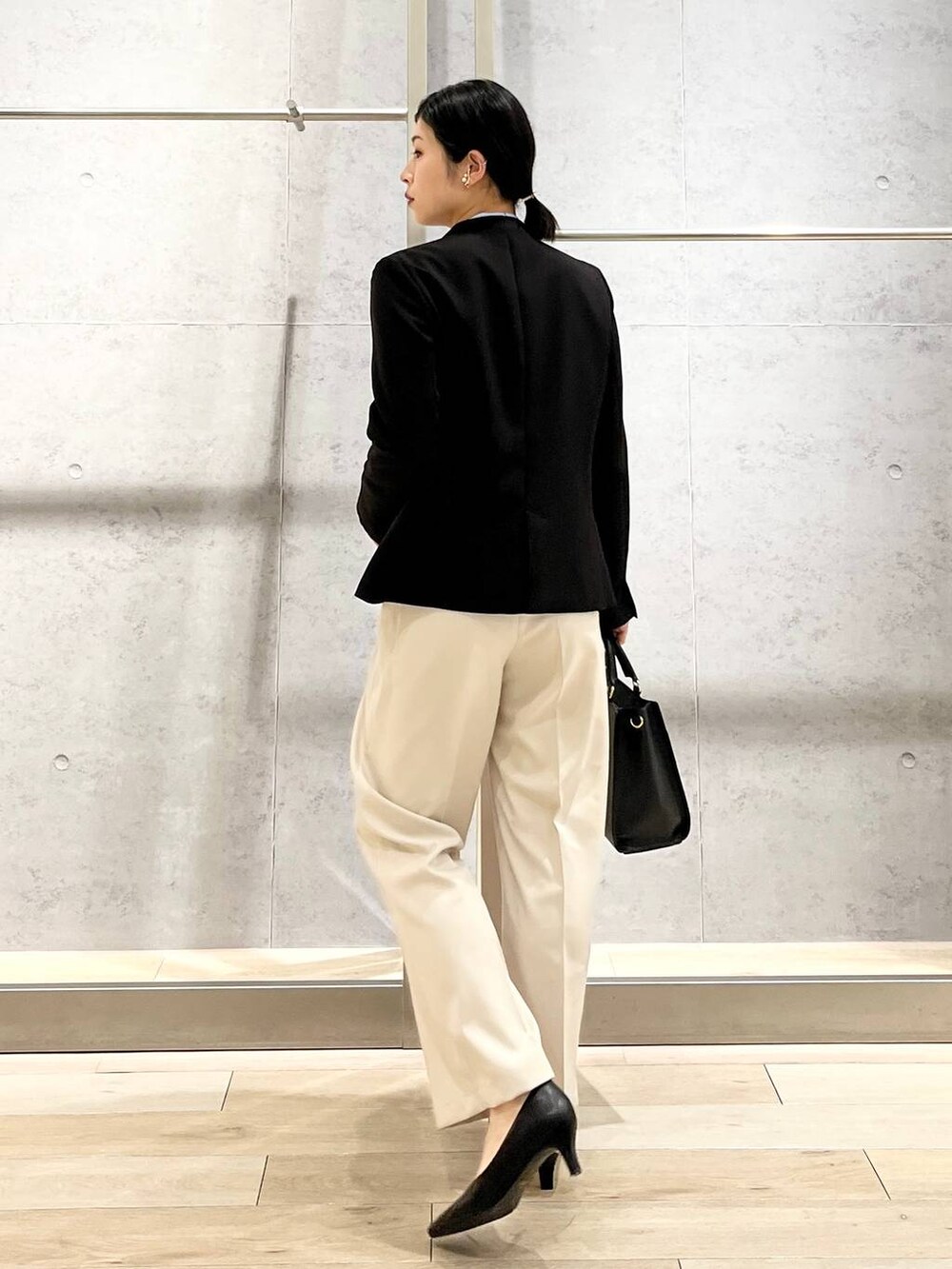 ブルー系のシャツ/ブラウス、ブラック系のノーカラージャケット、ブラック系のショルダーバッグを着用したレディースの冬コーディネートの5枚目の写真