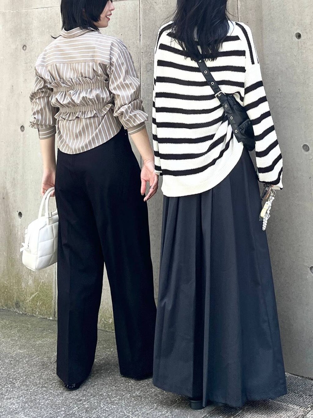 ブラック系のニット/セーター、ブラック系のショルダーバッグ、ブラック系のパンプスを着用したレディースの夏コーディネートの4枚目の写真