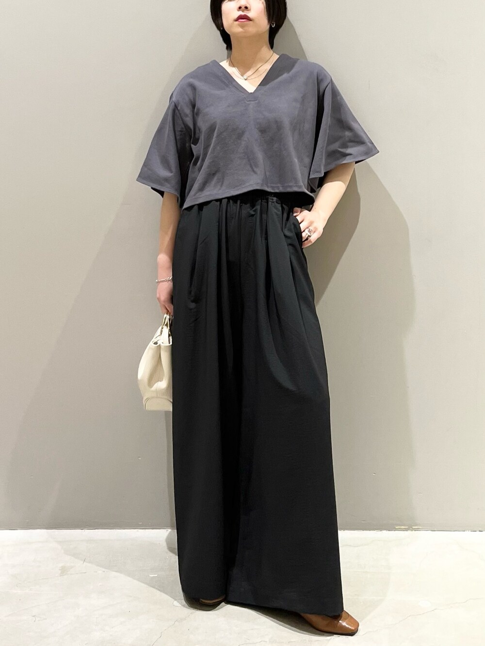 グレー系のTシャツ/カットソー、ブラック系のその他パンツ、ホワイト系のバッグを着用したレディースの春コーディネートの5枚目の写真