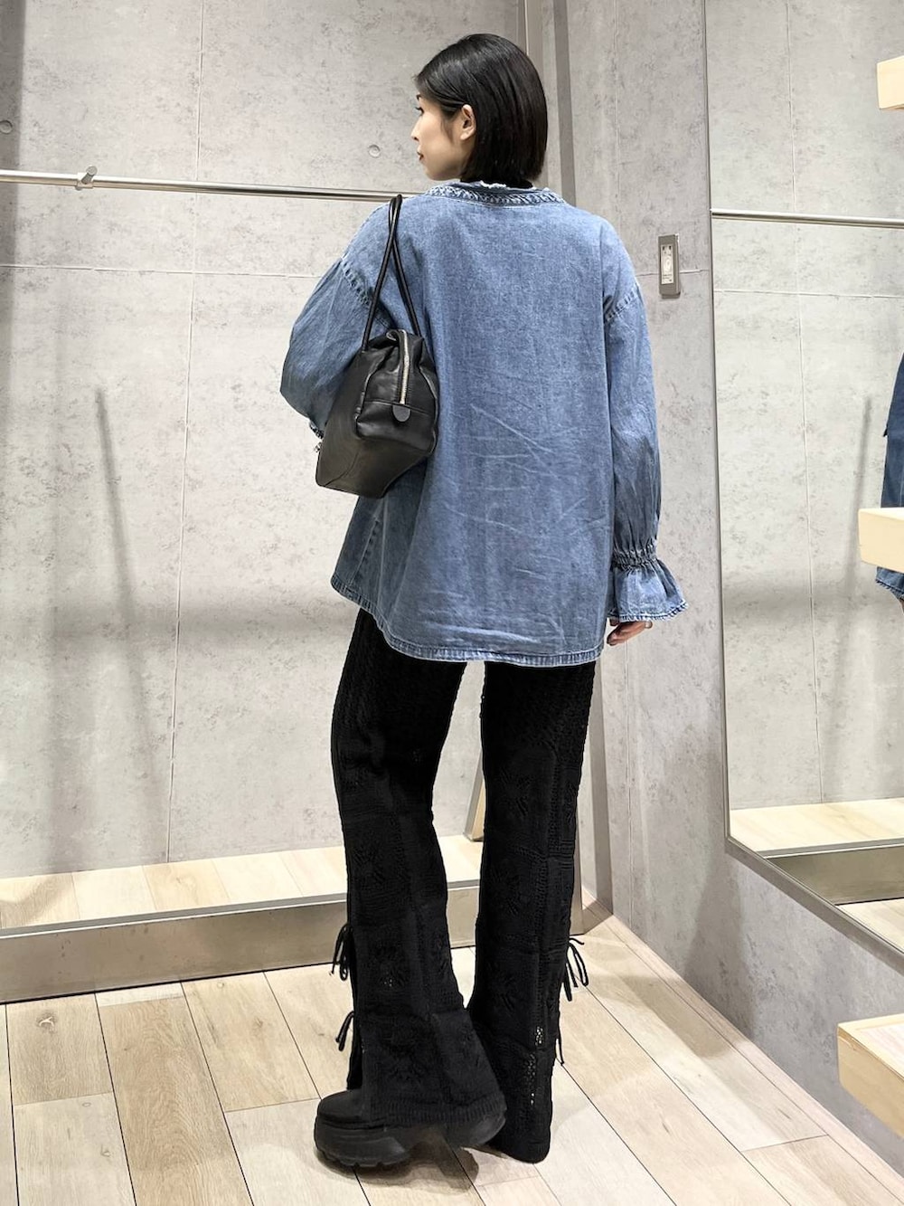 ブラック系のブーツ、ブラック系のボストンバッグ、ブラック系のその他パンツを着用したレディースの冬コーディネートの5枚目の写真