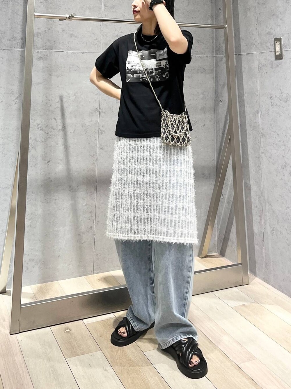 ブラック系のTシャツ/カットソー、ブラック系のサンダル、ブルー系のデニムパンツを着用したレディースの夏コーディネートの4枚目の写真