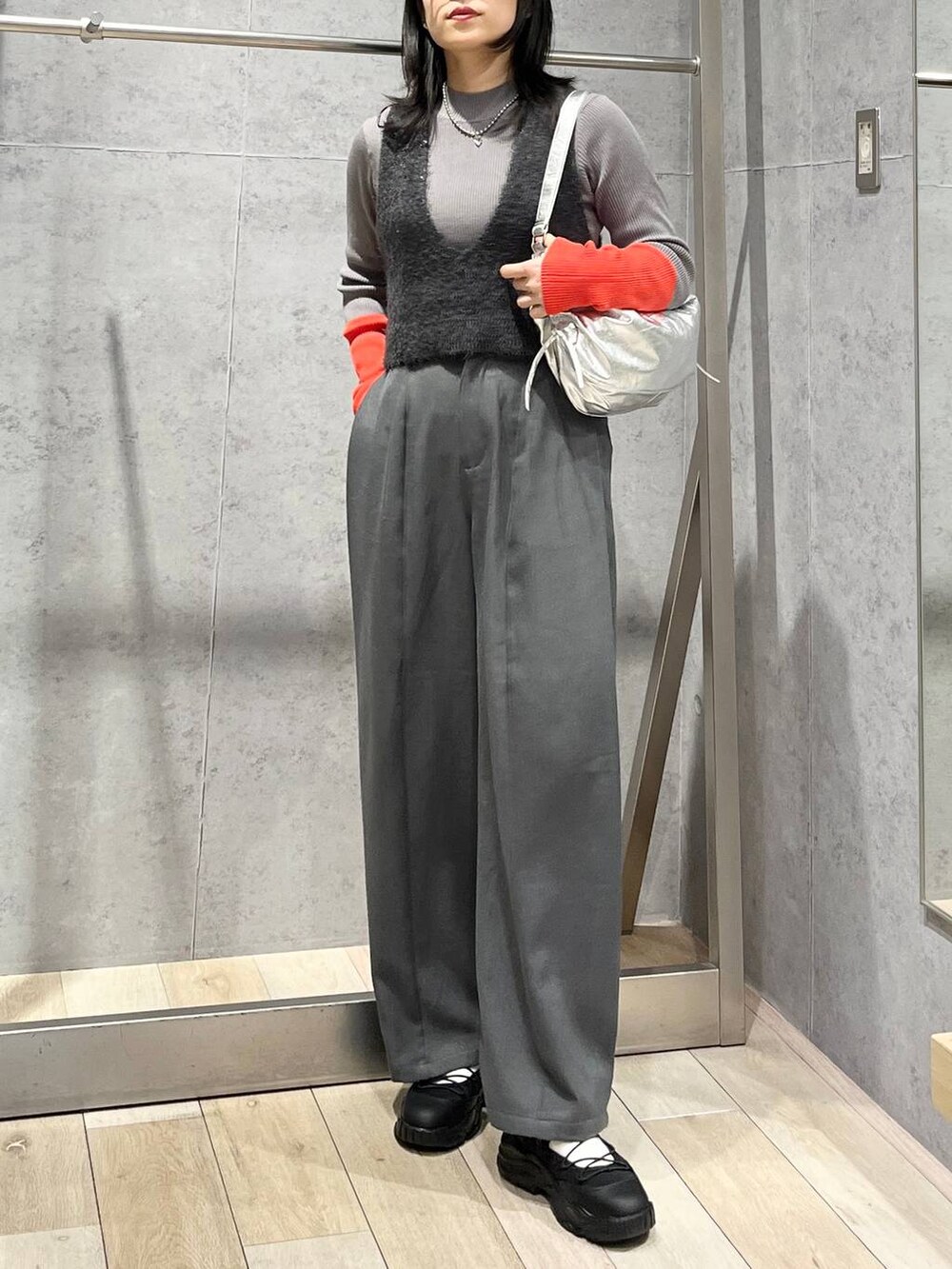 グレー系のニット/セーター、グレー系のベスト、グレー系のショルダーバッグを着用したレディースの冬コーディネートの6枚目の写真