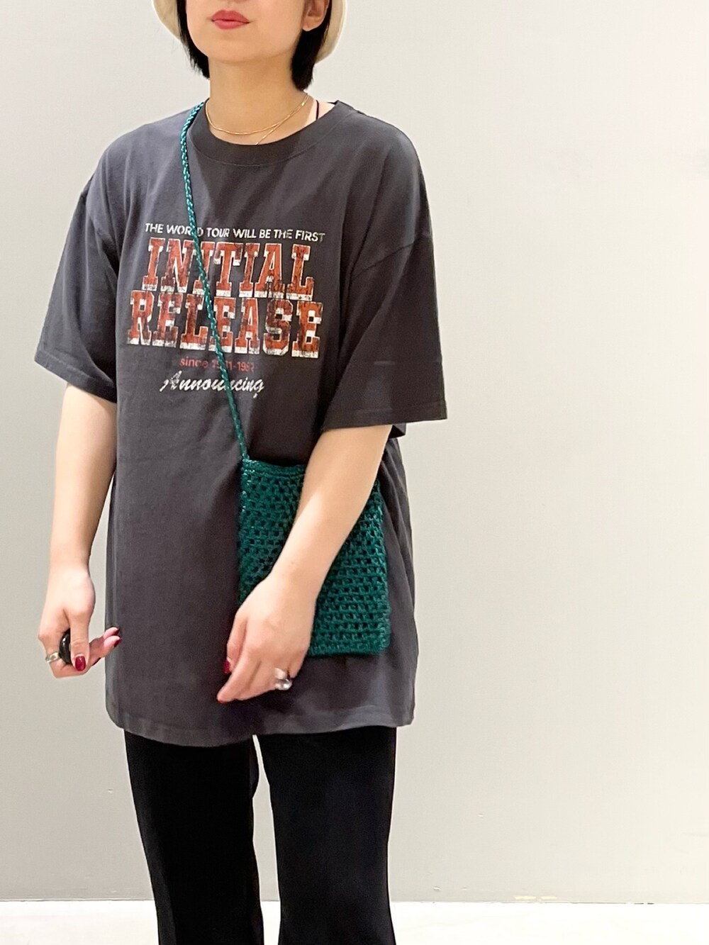 ブラック系のパンツ、ホワイト系のサンダル、グリーン系のショルダーバッグを着用したレディースの秋コーディネートの2枚目の写真