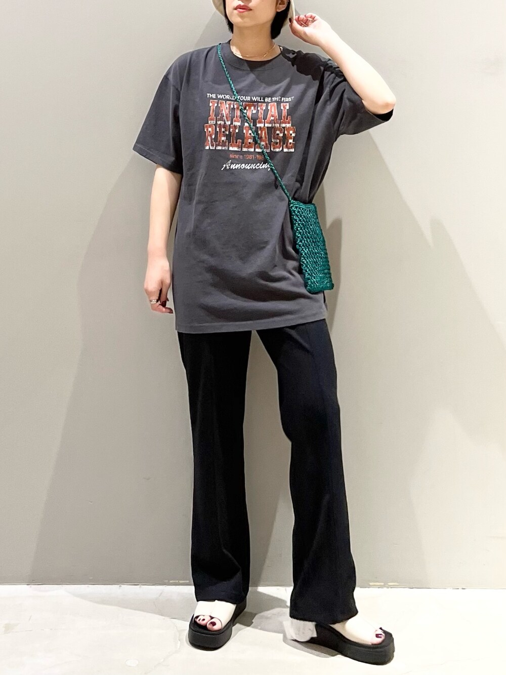 ブラック系のパンツ、ホワイト系のサンダル、グリーン系のショルダーバッグを着用したレディースの秋コーディネートの8枚目の写真