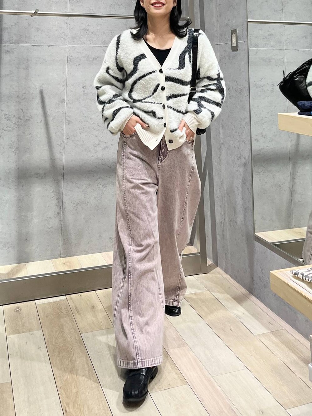 ホワイト系のカーディガン/ボレロ、ブラック系のローファー、ブラック系のショルダーバッグを着用したレディースの冬コーディネートの2枚目の写真