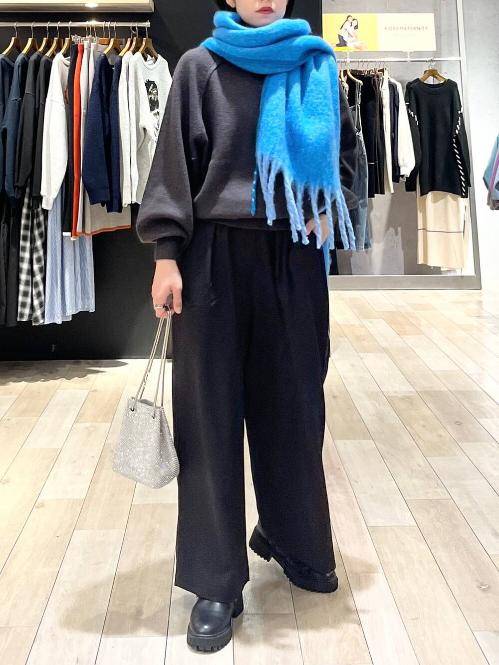 シルバー系のショルダーバッグ、グレー系のニット/セーター、ブラック系のその他パンツを着用したレディースの秋コーディネートの7枚目の写真