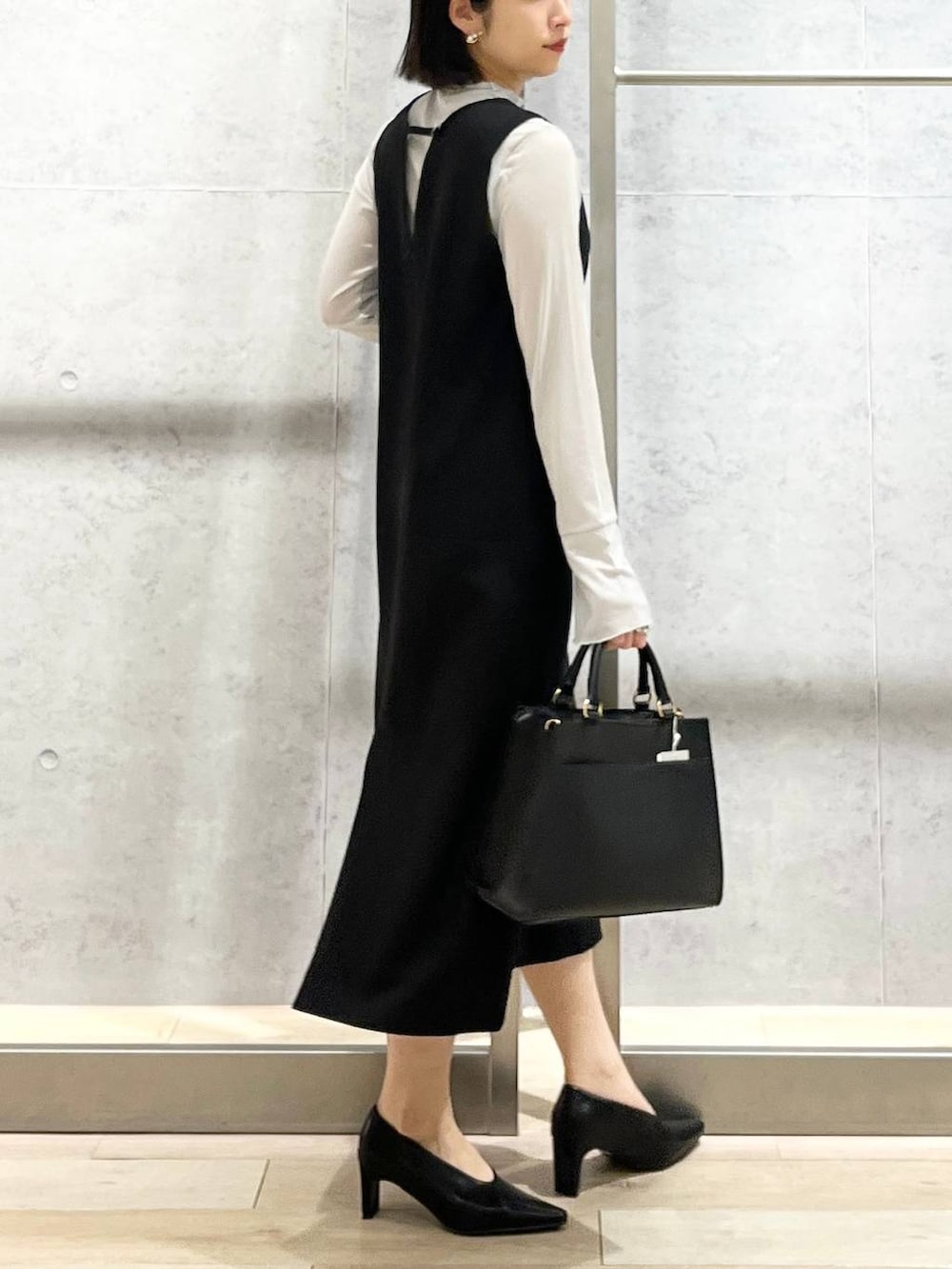 ブラック系のパンプス、グレー系のTシャツ/カットソー、ブラック系のショルダーバッグを着用したレディースの冬コーディネートの5枚目の写真