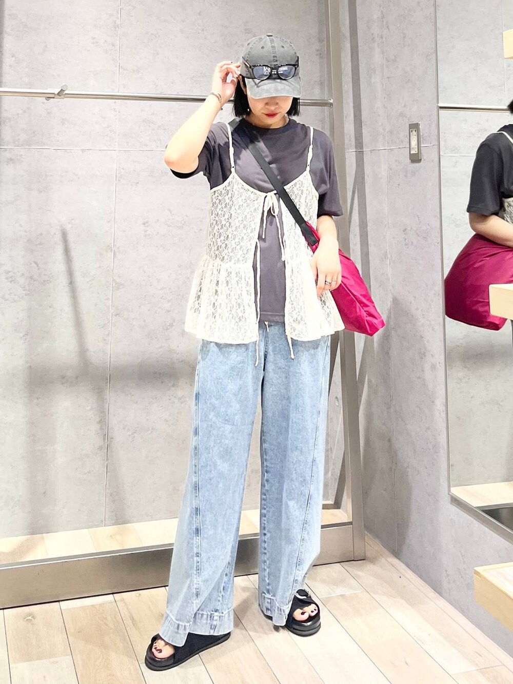 ブルー系のデニムパンツ、ブラック系のサンダル、ピンク系のショルダーバッグを着用したレディースの夏コーディネートの6枚目の写真