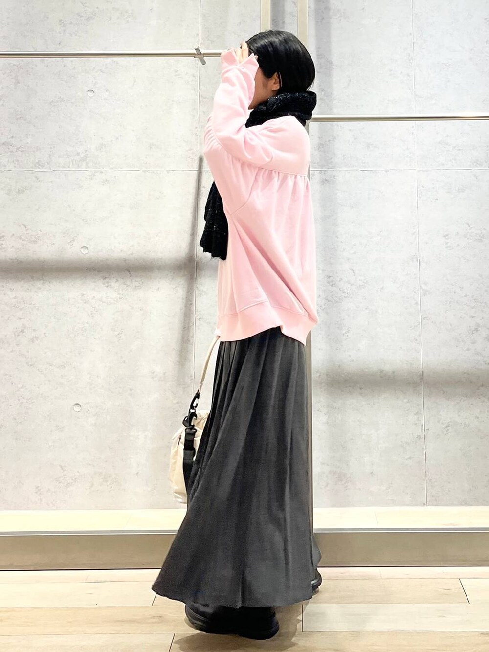 ホワイト系のショルダーバッグ、ピンク系のスウェット、ブラック系のブーツを着用したレディースの秋コーディネートの6枚目の写真