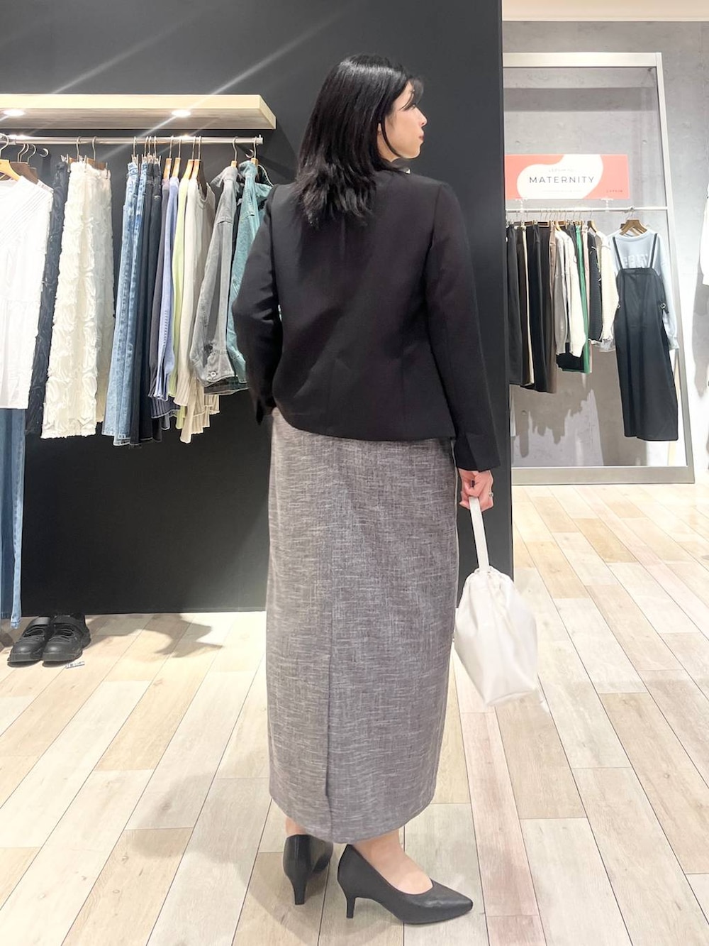 ブラック系のスーツジャケット、グレー系のジャンパースカート、ブラック系のTシャツ/カットソーを着用したレディースの冬コーディネートの6枚目の写真