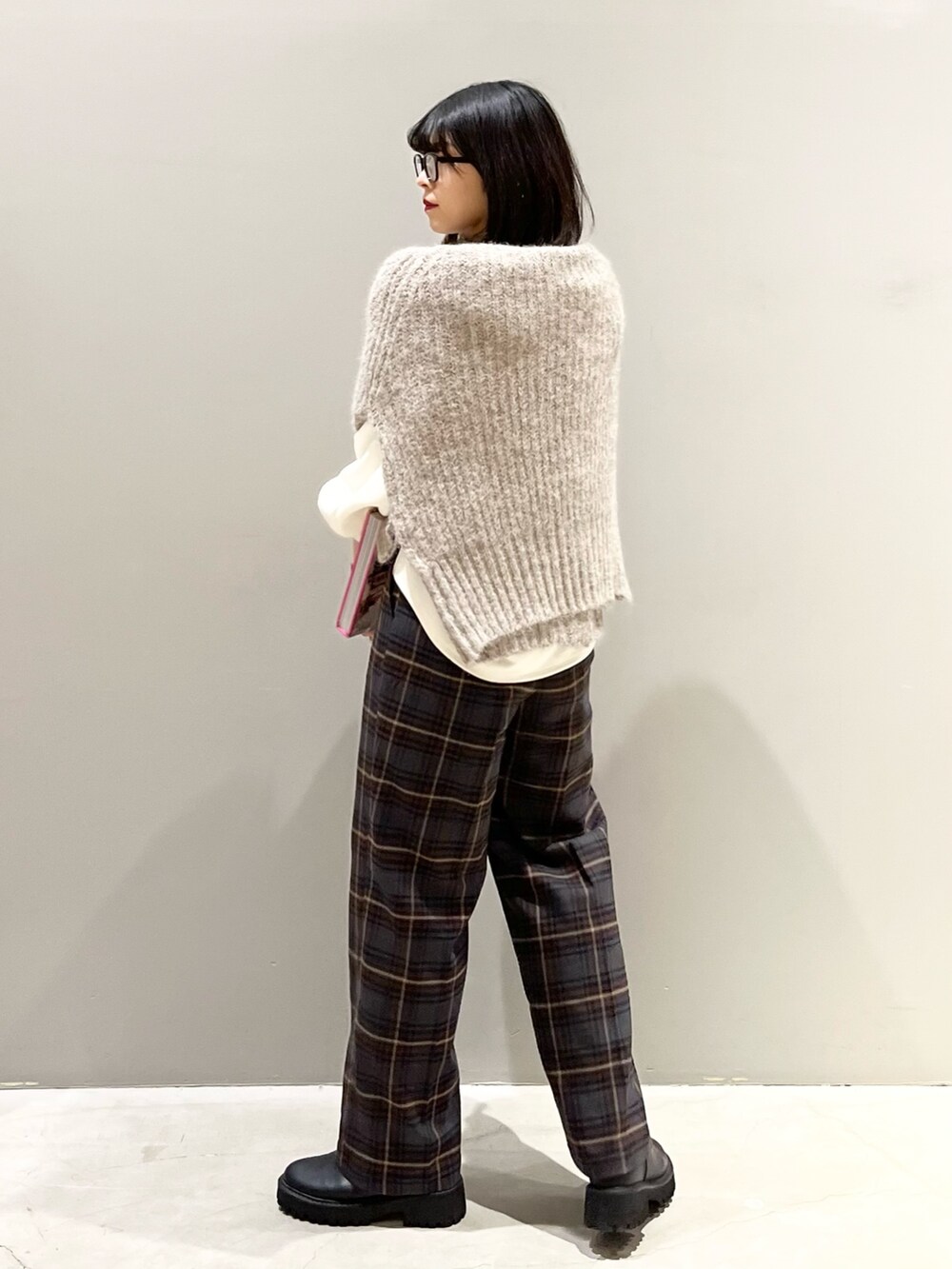 ブラウン系のスラックス、ブラック系のブーツ、ベージュ系のカーディガン/ボレロを着用したレディースの冬コーディネートの4枚目の写真