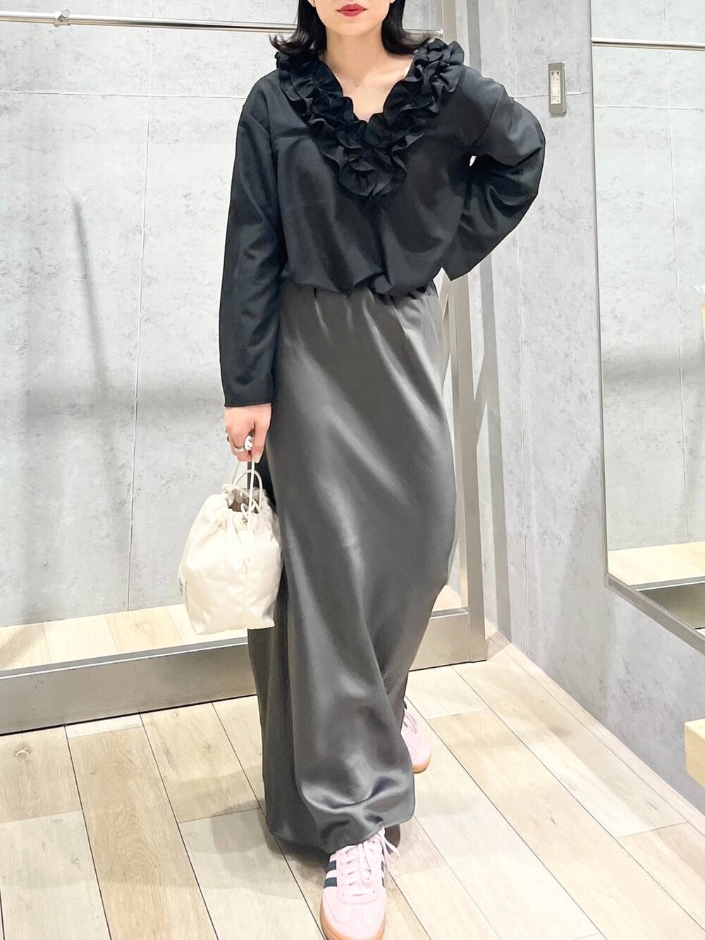 グレー系のスカート、ホワイト系のショルダーバッグ、ブラック系のキャップを着用したレディースの春コーディネートの7枚目の写真