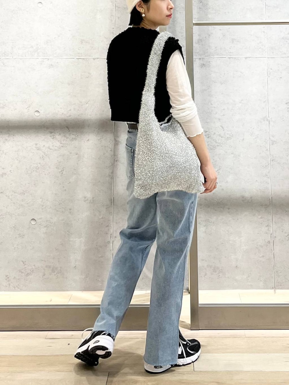 ホワイト系のTシャツ/カットソー、ブルー系のデニムパンツ、シルバー系のショルダーバッグを着用したレディースの秋コーディネートの4枚目の写真