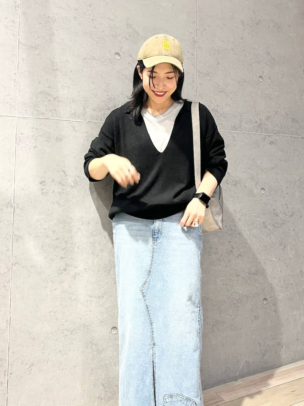 グレー系のTシャツ/カットソー、ブルー系のデニムスカート、ブラック系のニット/セーターを着用したレディースの冬コーディネートの2枚目の写真