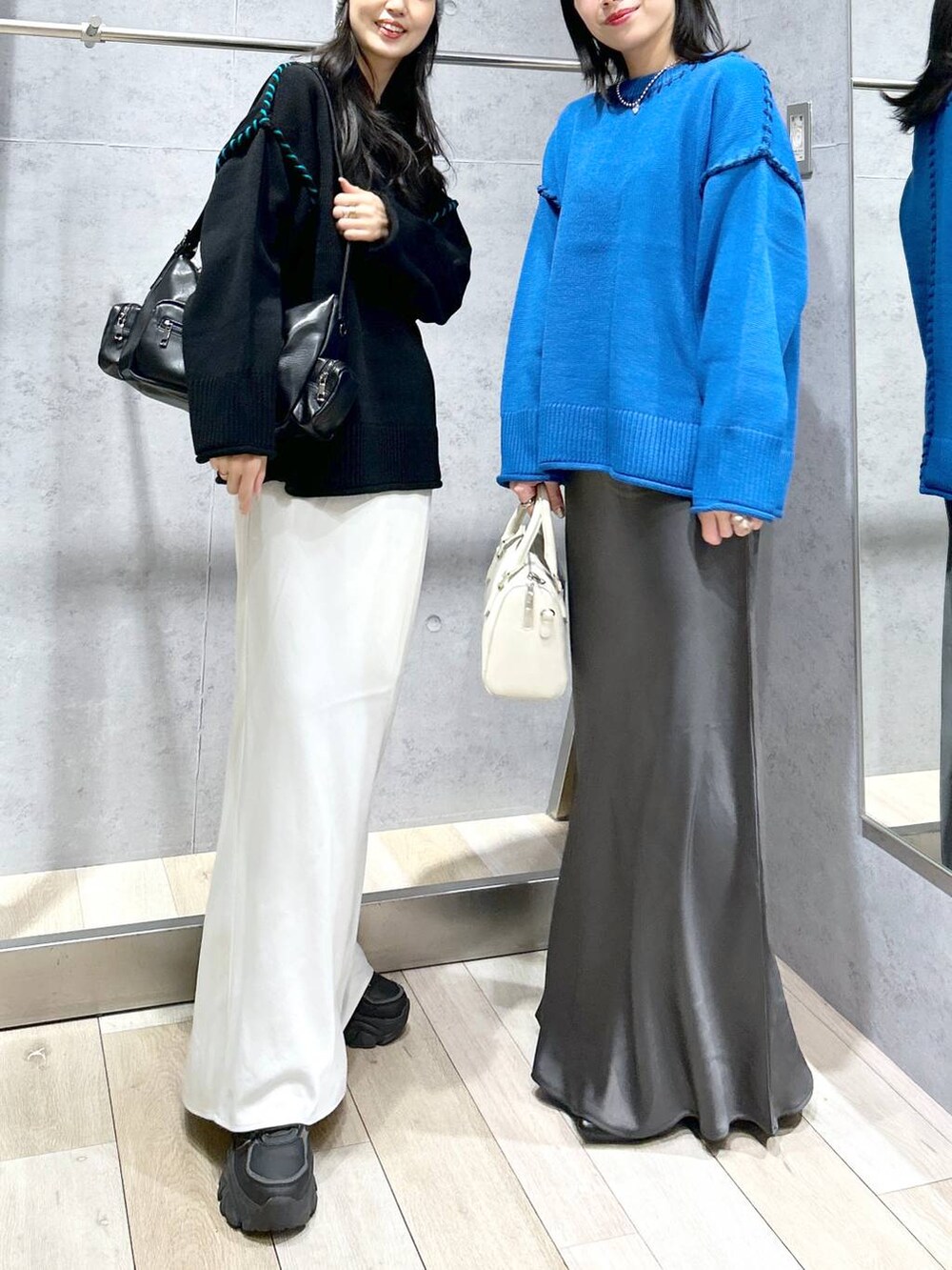 グレー系のスカート、ブラック系のパンプス、ホワイト系のボストンバッグを着用したレディースの冬コーディネートの4枚目の写真