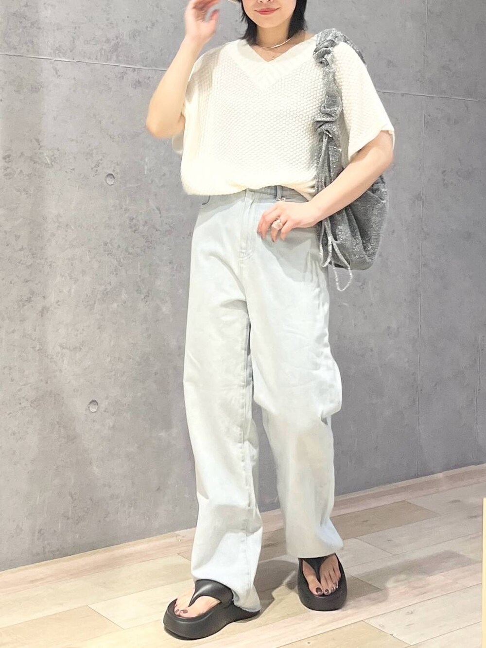 ブラック系のサンダル、ブルー系のデニムパンツ、ホワイト系のニット/セーターを着用したレディースの夏コーディネートの6枚目の写真