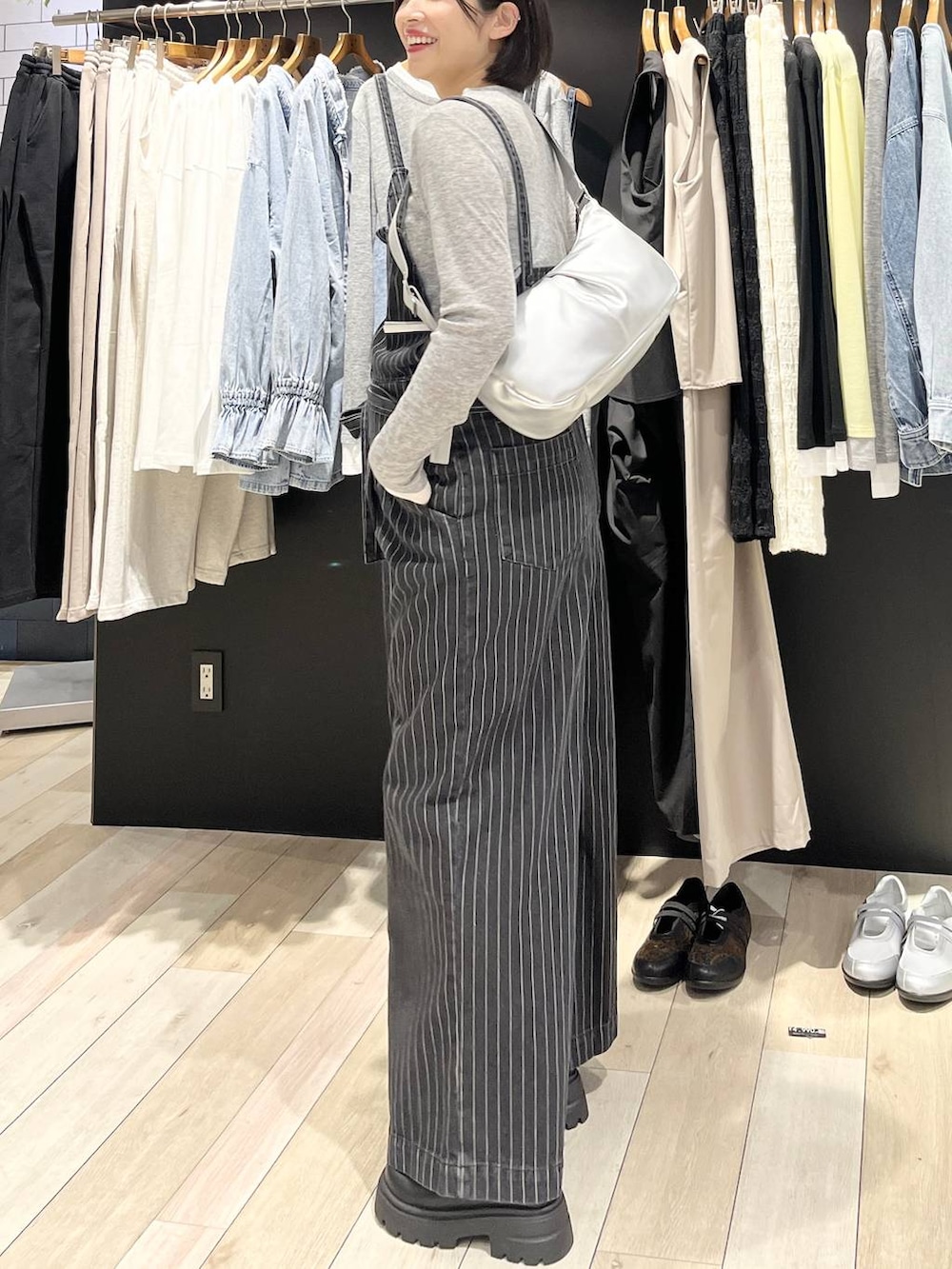 ブラック系のブーツ、グレー系のTシャツ/カットソー、ブラック系のサロペット/オーバーオールを着用したレディースの冬コーディネートの2枚目の写真