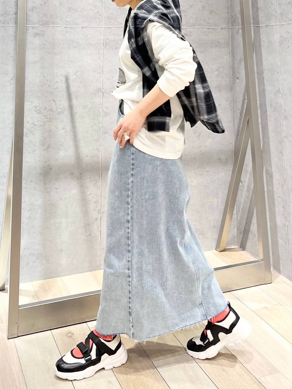 ホワイト系のTシャツ/カットソー、ブルー系のスカート、ホワイト系のスニーカーを着用したレディースの冬コーディネートの3枚目の写真