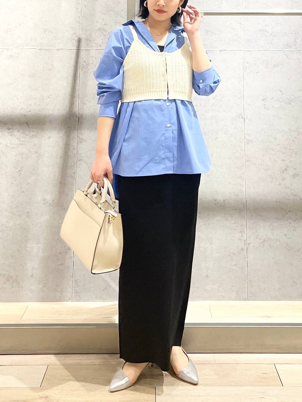 ブルー系のシャツ/ブラウス、ブラック系のスカート、ホワイト系のショルダーバッグを着用したレディースの冬コーディネートの9枚目の写真